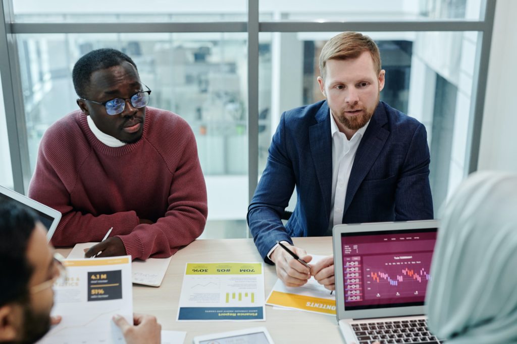 An image of IT professionals sitting around a table discussing data management as this article is about the top ETL tools for extract, transform, and load capabilities and ETL software.